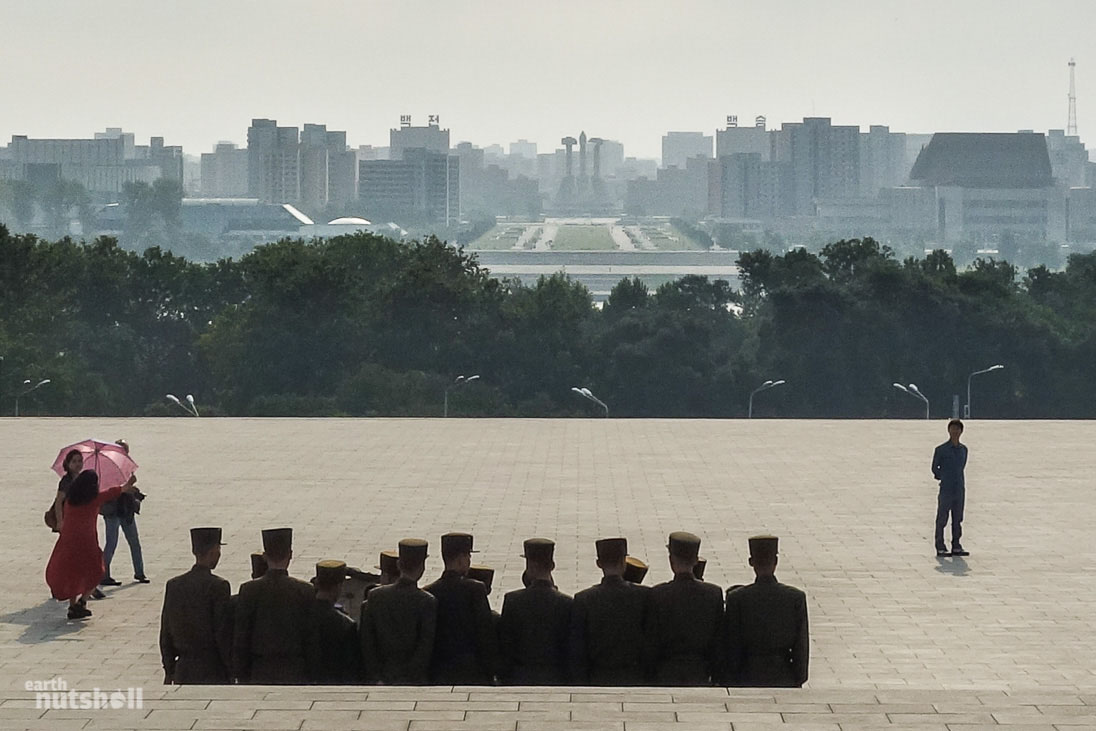 Young Korean People’s Army recruits just after bowing to the Great Leaders at the Mansudae Grand Monument on Mansu Hill. In the distance, you can see one of Pyongyang’s most recognisable icons, the Monument to the Korean Workers Party.