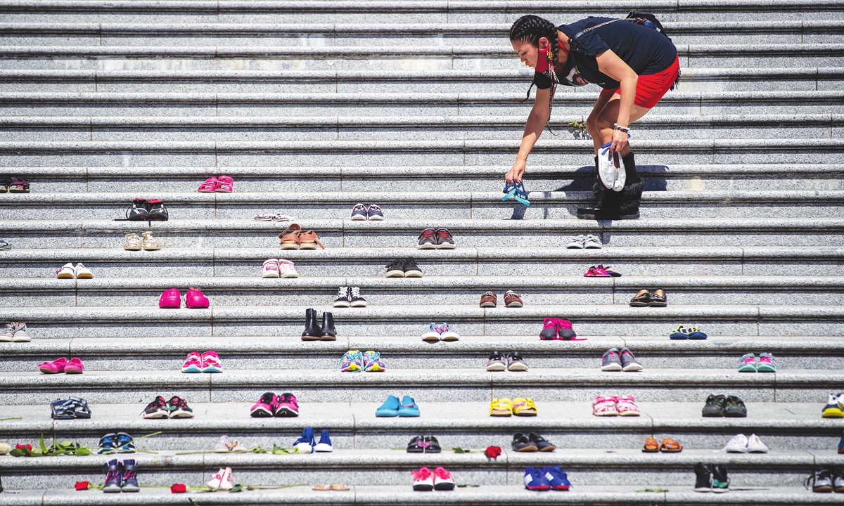 Lorelei Williams puts one of 215 pairs of children's shoes on the steps of the Vancouver Art Gallery. Photo: VCG