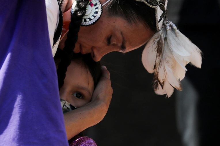 A woman embraces her daughter during a rally after the remains of 215 children were found at a residential school in Toronto, Ontario, Canada, June 6, 2021. [Chris Helgren / REUTERS] (Reuters)