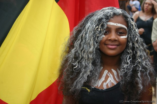  A proud Indigenous girl in front of the Aboriginal flag.