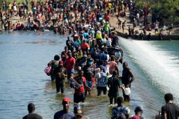 Haitian migrants use a dam to cross into the United States from Mexico on Saturday in Del Rio, Texas. The Biden administration plans the wide scale expulsion of Haitian migrants by putting them on flights to Haiti starting Sunday, an official said Friday.