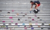 Lorelei Williams puts one of 215 pairs of children's shoes on the steps of the Vancouver Art Gallery. Photo: VCG